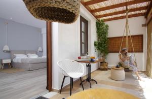 a woman sitting on a swing in a living room at Syros Wellness Luxury Suites in Finikas