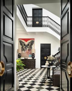 a hallway with black doors and a checkered floor at Plaza 18 in Vejer de la Frontera