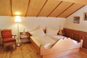 een slaapkamer met een bed, een lamp en een stoel bij Haus Schönblick in Brand