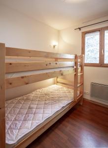 Un dormitorio con dos literas en una habitación. en Florence 2 103 - FAMILLE appart 4 pers Valfréjus, en Valfréjus