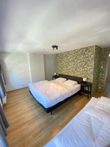 a bedroom with two beds and a wall with flowers at Villa Maredan in Ostend