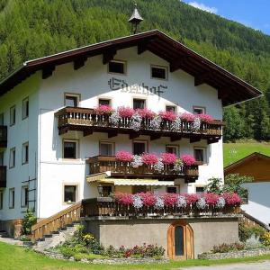 a building with flowers on the balconies of it at Pension Ederhof in San Giacomo