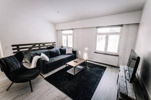 a living room with a couch and a table at SleepWell House Pyhätunturi with Sauna close to lake in Pelkosenniemi