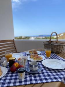 a blue and white checkered table with food and drinks at Spanos Apartments in Agios Petros