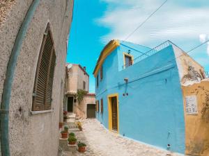 a blue building in an alley with potted plants at panoramic LOFT Fora e ' Muros with sea view common terrace , Ammentos Posada in Posada