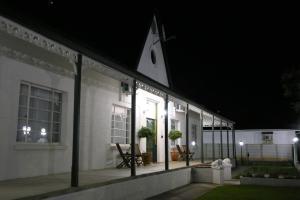 a white house at night with lights on it at Victorian Square Guesthouse in Graaff-Reinet