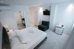 阿什杜德Unique Hotel Ashdod的卧室配有白色的床和椅子