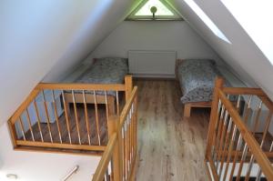 a attic room with two bunk beds and stairs at Apartament Stara Leśniczówka in Polnica