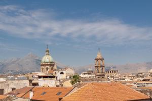 um grupo de edifícios com montanhas ao fundo em Hotel Concordia em Palermo