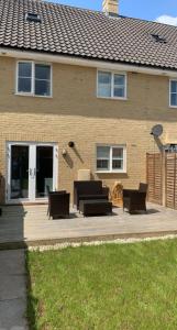 a patio with couches and chairs in front of a house at SUNSHINE ROOM in Colchester