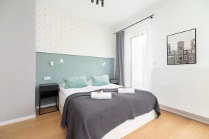 a bedroom with a bed with two towels on it at Apartments Steam Park Old Town Cracow by Renters in Krakow