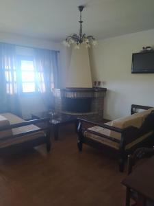 een woonkamer met 2 bedden en een tafel bij STUDIOS CHRISTINA in Póroi