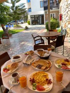 una mesa con platos de comida encima en Ksamil Central Park Hotel en Ksamil