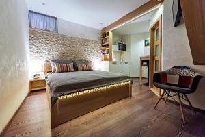 a bedroom with a bed and a brick wall at Ground Floor Gem (city centre) in Rovinj