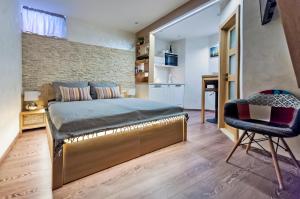 a bedroom with a bed and a chair at Ground Floor Gem (city centre) in Rovinj