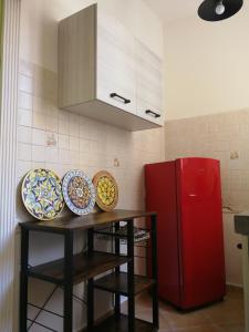 una cucina con piatti su un tavolo accanto a un frigorifero rosso di CASA 739 a Catania