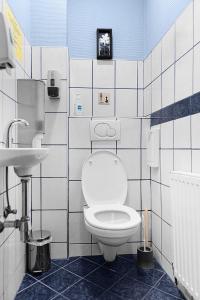 a white toilet sitting in a bathroom next to a sink at Hotel-Pension Wild in Vienna