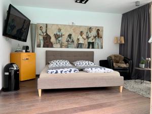 ein Schlafzimmer mit einem Bett und einem Gemälde an der Wand in der Unterkunft Guesthouse Passau in Passau