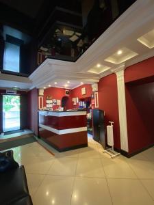 un restaurante con bar en una sala con paredes rojas en Duna Hotel, en Kazán