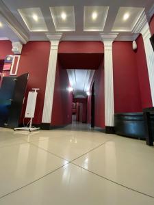 a room with a red wall with columns and a cross at Duna Hotel in Kazan