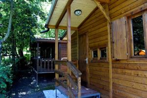 a cabin with a clock on the side of it at Stura River Village RAFTING in Gaiola