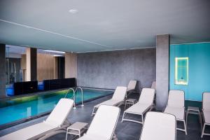 uma sala de conferências com piscina e cadeiras brancas em SHAMBALA WELLNESS CLUB em Rozhny