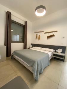 1 dormitorio con cama grande y ventana grande en B&B CASA CALETA, en Porto Cesareo