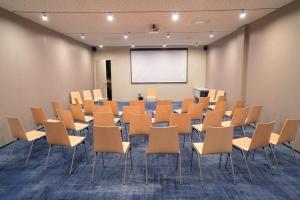 einen Konferenzraum mit Stühlen und einem weißen Bildschirm in der Unterkunft SHAMBALA WELLNESS CLUB in Rozhny