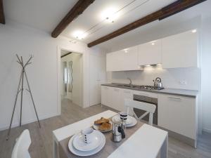 a kitchen with white cabinets and a table with food on it at Residence SS Giovanni e Paolo in Venice