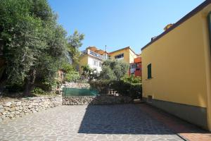 a courtyard of a house with a stone wall at Borgo Antico - Casa del commodoro in Tellaro
