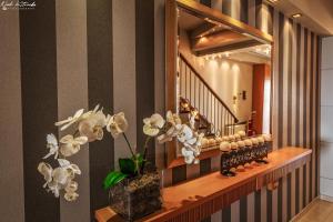 a hallway with a mirror and a vase with flowers at Hotel Avra in Paralia Katerinis
