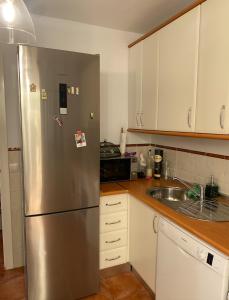 a kitchen with a stainless steel refrigerator and a sink at Lomas de Sancti Petri in Cádiz