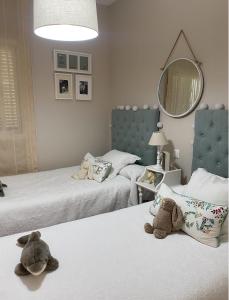 two stuffed animals sitting on two beds in a bedroom at Lomas de Sancti Petri in Cádiz