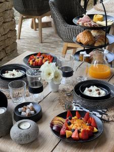 una mesa cubierta con platos de comida y fruta en Le Mas de Béthel en Gordes