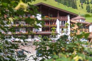 a large white building with a large balcony at Hotel Genziana in Selva di Val Gardena