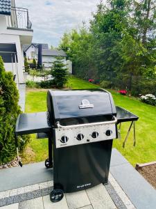 a grill sitting on a patio in a yard at Apartamenty Różany Ogród in Łeba