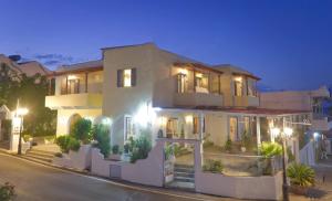 a large white building with plants in front of it at Saronic View in Skala