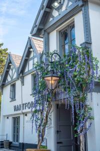 Un edificio con una corona di fiori viola sopra. di Hartford Hall on School Lane a Northwich