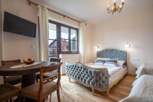 a bedroom with a bed and a table and a dining room at Porto in Karwia