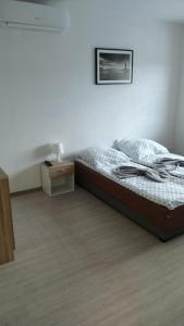 a bedroom with a bed and a nightstand with a picture at Na Fali in Dziwnów