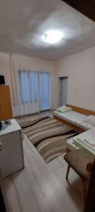 an empty room with two beds and a table in it at Guest House Kukera in Pavel Banya