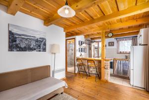 a living room with a couch and a kitchen at Sunset Hill Vendégház Zebegény in Zebegény