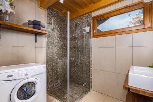 a bathroom with a washing machine and a shower at Sunset Hill Vendégház Zebegény in Zebegény