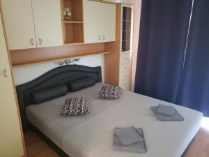 1 dormitorio con 1 cama con 2 almohadas en Risika Apartmani, en Risika