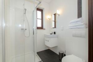 a white bathroom with a shower and a toilet at Porto in Karwia +80 photos