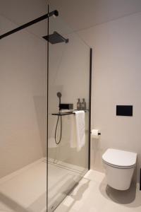 a bathroom with a glass shower with a toilet at Plaza Apartments in Opatija