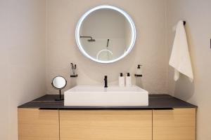 a bathroom with a white sink and a mirror at Plaza Apartments in Opatija