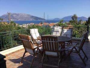 patio con mesa y sillas en el balcón en Cephalonia Sami, luxury apartment., en Sami