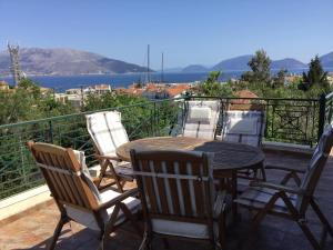 patio con mesa y sillas en el balcón en Cephalonia Sami, luxury apartment., en Sami