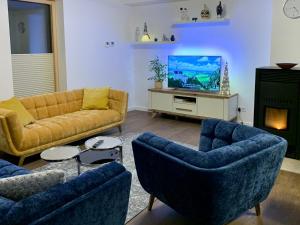 sala de estar con 2 sofás y TV en Green Hill House, en Līgatne